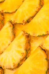 Pineapple juicy yellow slices as a background.