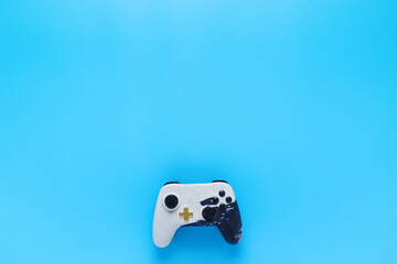 Blue background with a white joystick, overhead shot, graphic resource for video game advertising
