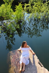 Beautiful girl in white dress enjoys  summer day in nature