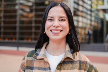 One hispanic woman looking at camera with friendly expression. Close up individual portrait of a...