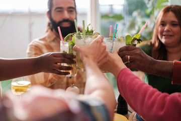Group of friends from different cultures toasting with a cocktail at a party. Concept: celebrate, friendship