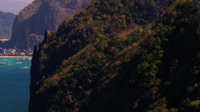 Aerial reveal shot of El Nido tropical paradise island surrounded by crystal blue sea and sail boats. Travel video of Bukal island El Nido Philippines on sunny summer day