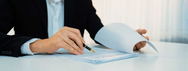 Business executive signing contract agreement document on the bale with the help from company...