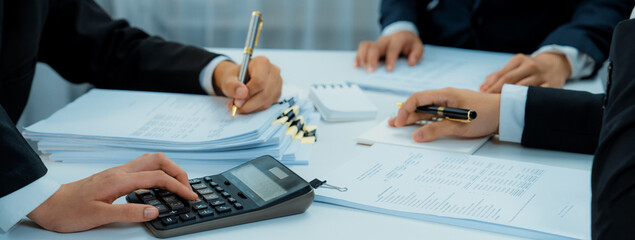 Corporate accountant team use calculator to calculate and maximize tax refunds and improve financial performance based on financial data report. Modern business accounting in panorama. Shrewd