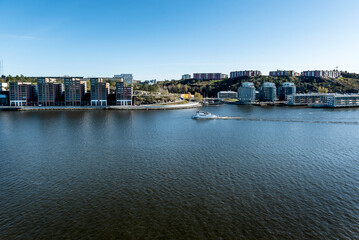 Obraz premium Cruising ship passing by Residential buildings of Nacka municipality in Stockholm wider urban area. Stockholm archipelago 