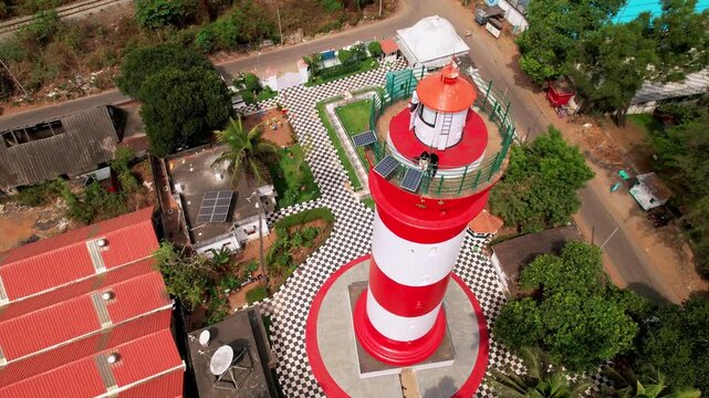 Alleppey Lighthouse with red and white stripes, aerial view, Alappuzha, Kerala, India. Lighthouse with red and white stripes with palm trees on a cloudless blue sky