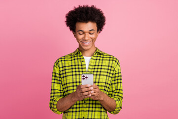 Portrait of nice young man use smart phone wear shirt isolated on pink color background