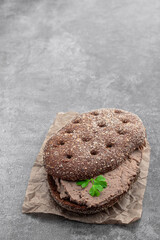 Liver meat pate spread on rye bread on gray background