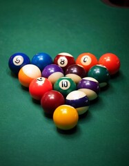 Close-up of colorful billiard balls arranged in triangle on green pool table for game setup