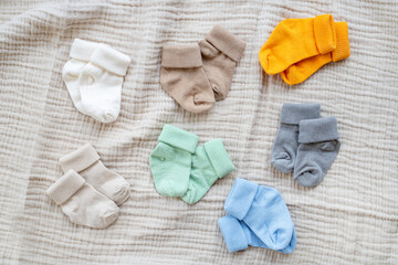 Colorful baby socks on beige background. Top view.