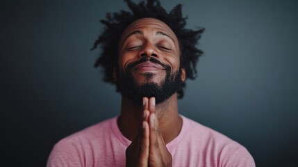 Fototapeta premium An evocative image of a person with their hands clasped in front of their face, set against a dark background, representing introspection, prayer, or deep thought.