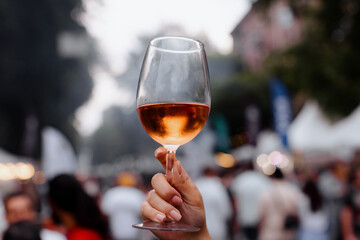 Adult holds up a glass  wine enjoying the pleasant weather