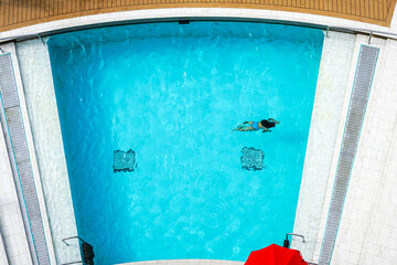 Cruise liner relaxation zone water pool with blue water, top view, blurred human silhouette in water