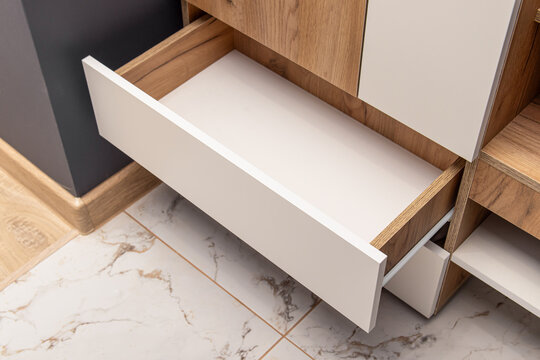 An open empty drawer in wooden cabinet. Wooden furniture