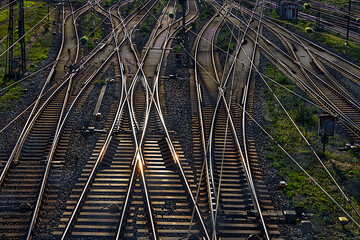Many railroad tracks with interchanges and electric cables