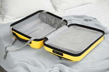 Open empty suitcase for travelling on bed indoors