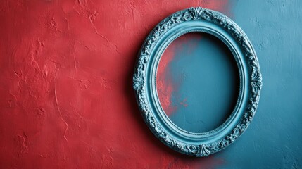 An ornate round frame is mounted on a wall that is painted half red and half blue, creating a striking visual combination of colors and classic design elements.