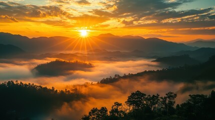 Obraz premium A mist rises over a mountainous valley, creating a serene and mystical atmosphere. The fog gently blankets the landscape, with mountain peaks emerging through the haze