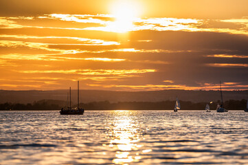 Segelboote auf einem See bei Sonnenuntergang