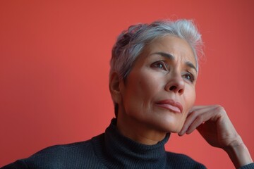 A person dressed in a turtle neck sweater is looking away from the camera, possibly lost in thought