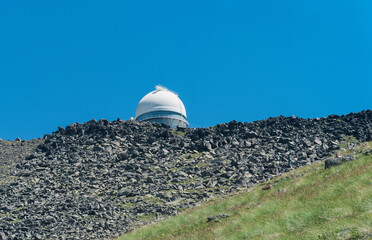 observatory on top of a mountain against a blue sky