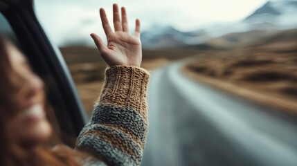 A young woman waves enthusiastically from a car window while on a scenic road trip, capturing the spirit of freedom, joy, and the open road adventure.