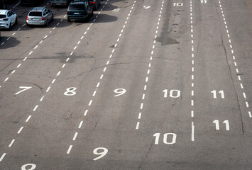 Vehicles in a raw on the port terminal ready for loading in a ferry. Road markings