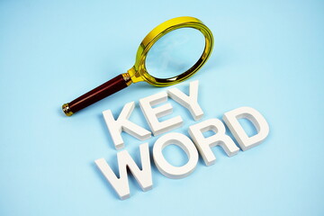 Keyword word with magnifying glass top view on blue background