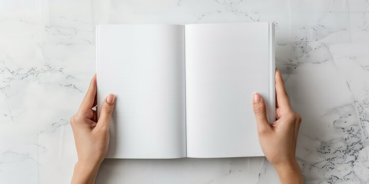 Top view of woman holding open book with blank white pages on white table with space for text - Powered by Adobe