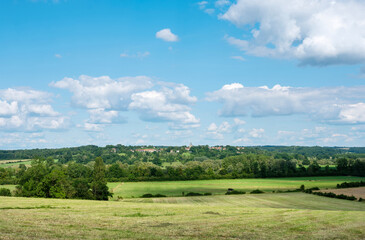 countryside landscape of pays d'argonne with village and trees under blue summer sky