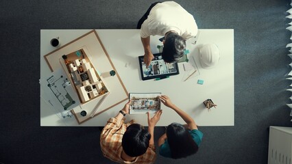 Top down view of civil architect looking at project plan while present to investor at meeting...