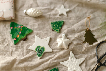 Modern authentic Christmas ornaments. Stylish handmade clay ornaments, baubles, scissors on rustic...