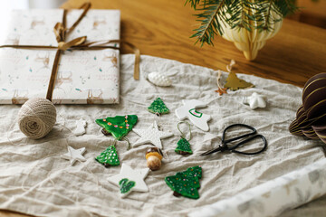 Wrapping christmas gift. Modern authentic Christmas ornaments. Stylish handmade clay tree, star and...