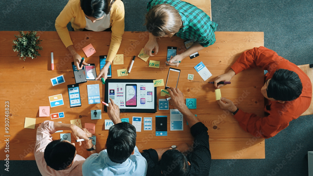 Poster top view of software developer team looking ux ui design for mobile phone interface from tablet whil