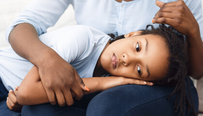 Family Support. Black woman comforting her offended kid who lying her head on mother's lap