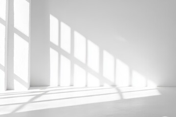 Fototapeta premium Sunlight streaming through large windows creates geometric shadows on white walls and floor