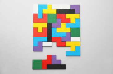 Colorful wooden puzzle pieces on light grey background, top view