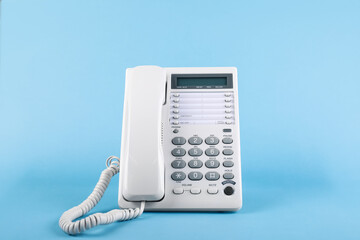 White telephone with handset on light blue background