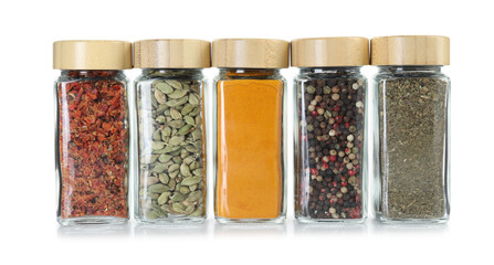 Different spices in glass jars isolated on white