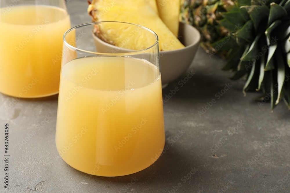 Canvas Prints tasty pineapple juice in glasses and fruits on grey textured table, closeup