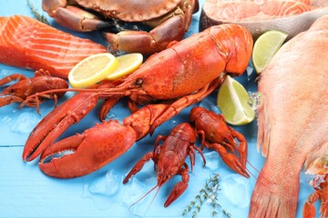 Different sea food on light blue wooden table, closeup
