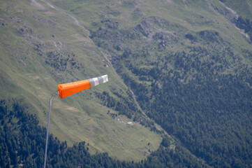Orange and white windsock in the mountain.