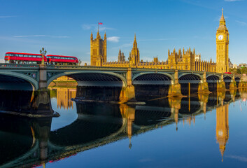 Houses of parliament with Big Ben tower and Westminster bridge reflected in Thames river, London, UK