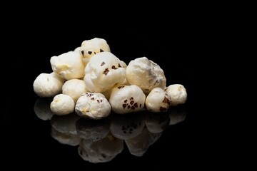 Fox Nut or Makhana Isolated on Black Background with Reflection and Copy Space, Also Known as Lotus Seed Pop, Euryale Ferox or Gorgon Nut