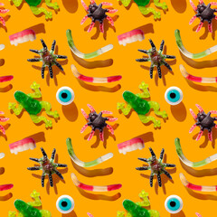 Halloween seamless pattern with sweet colorful assorted gummy candy on a orange background. Happy halloween holiday concept. Jelly sweets. National candy month