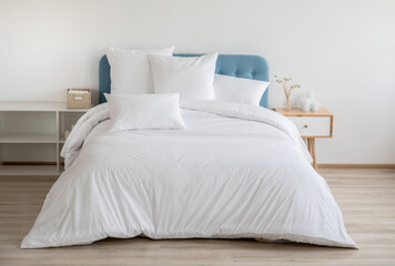 Cozy Bedroom with White Bedding This image depicts a serene bedroom featuring a bed adorned with pristine white bedding. The bed is complemented by a light blue, tufted headboard, adding a touch of 