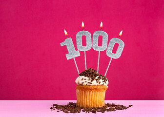 Birthday celebration with candle number 1000 - Chocolate cupcake on pink background