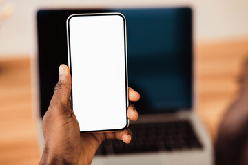 Useful App. Close-up of black man holding mobile phone with white blank screen. Mock up, rear view