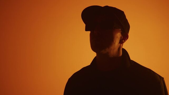 Close up of rap artist singing for a music video on an orange background