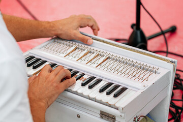 A man plays an Indian keyboard instrument. Indian wedding ceremony.